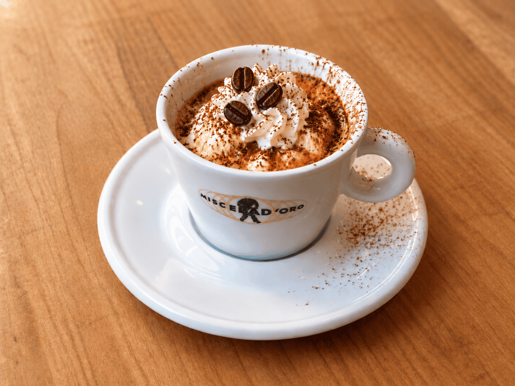 Affogato al caffe with vanilla gelato and espresso in a white cup.