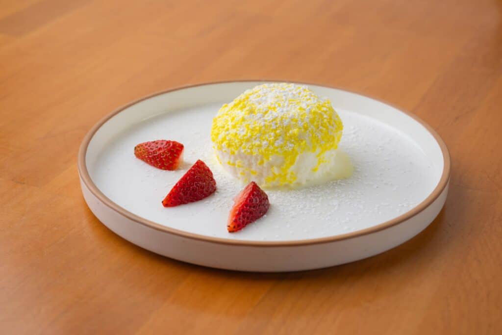 Delicious Italian dessert with strawberries and lemon-flavored cream on a white plate.