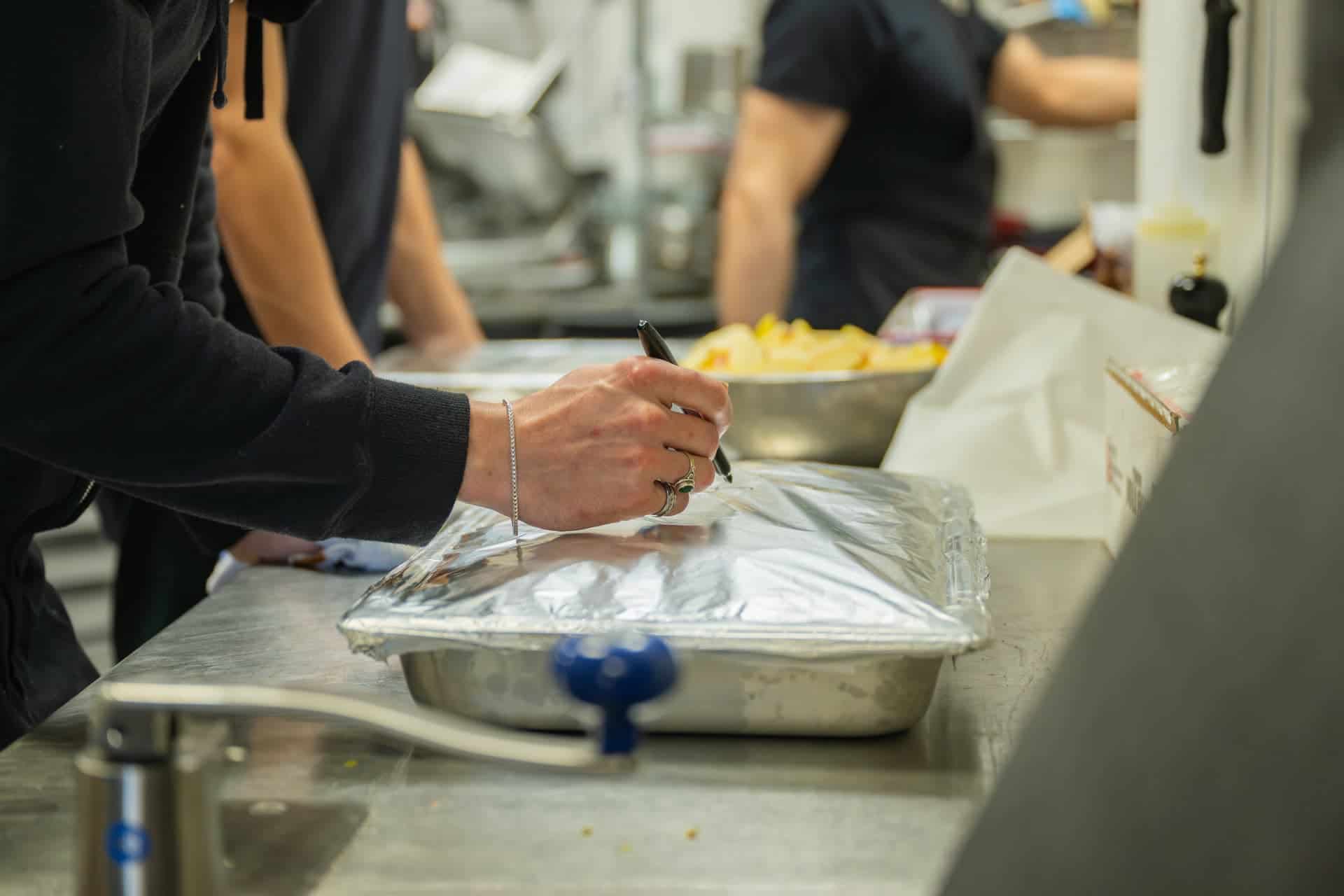 Labelling catering trays in the Vespa kitchen before a Sedona wedding